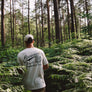 Hemp t-shirt with green coyote print on back on model in forest