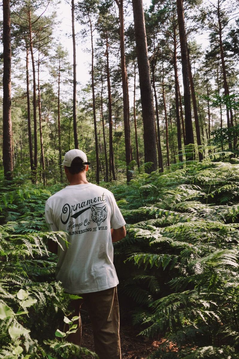 Hemp t-shirt with green coyote print on back on model in forest